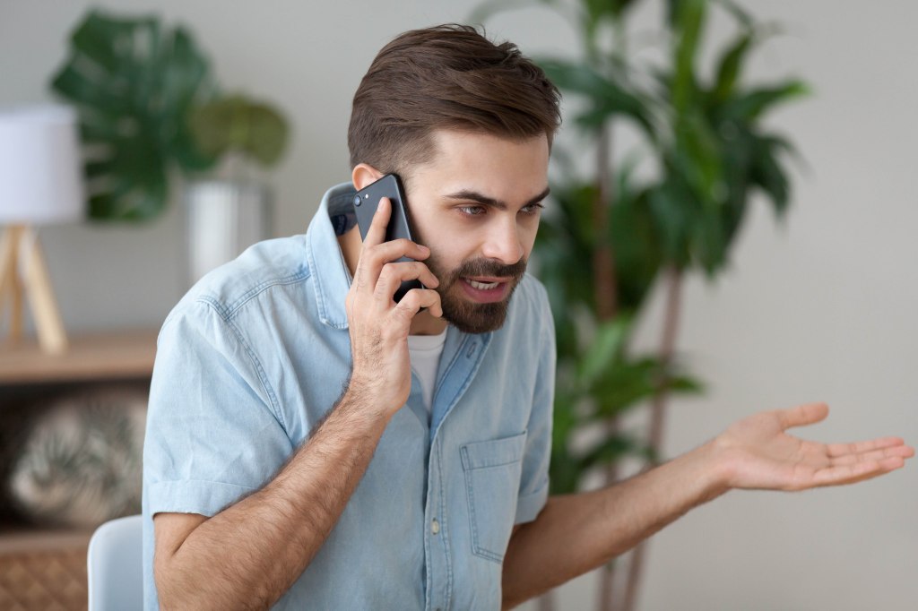 Angry man arguing on smartphone because of unemployment issues